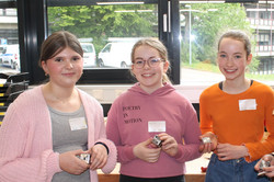 Drei Schülerinnen zeigen ihren eigens gebastelten Briefbeschwerer