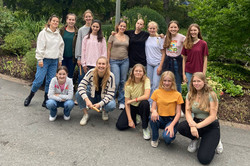 Eine Gruppe von Schülerinnen und Studentinnen posiert im Park als Gruppe