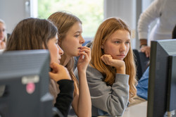 Drei Mädchen sitzen vor einem Computerbildschirm