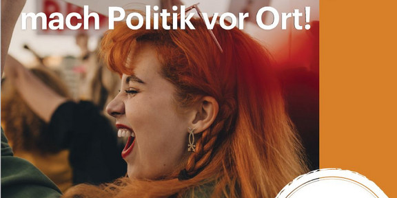 A woman at a demonstration, writing ‘Get involved in local politics'