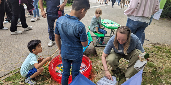 Zwei Kinder angeln in einem kleinen Kinderpool Holzfische