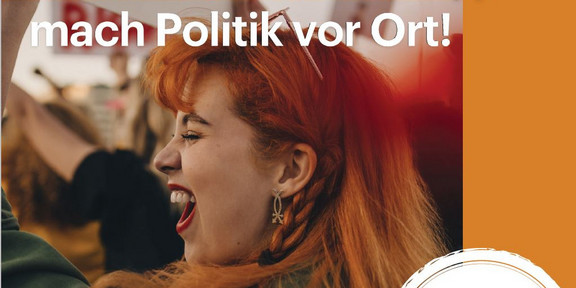 A woman at a demonstration, writing ‘Get involved in local politics'