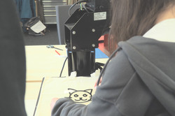 GD2024_CET_Klamotten veredeln Ein Mädchen bedient eine Plottermaschine und druckt ein Katzenmotiv auf ihr T-Shirt