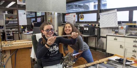 Two girls are in a workshop and enjoy working together.