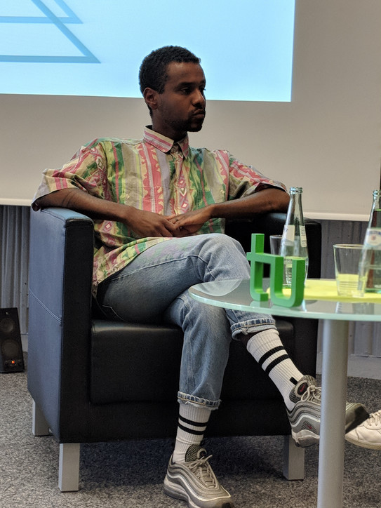 Moderator and activist Tarik Tesfu sits in a panel discussion