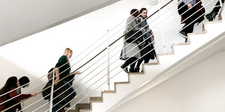 Female students climb a flight of stairs