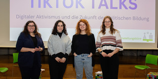 Vier Frauen stehen nebeneinander, hinter ihnen das Motto der Veranstaltung: TikTok Talks
