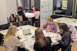 Three girls and a mentor sit around a table.