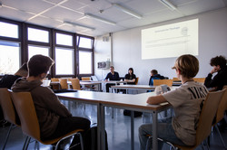 Boys sit in a seminar room and look at a screen.It says ‘systematic theology’