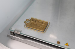 Goldfarbene rechteckige Metallplakette mit der Prägung 'Marie ♥ BFF' auf einer Glasplatte mit Metallrahmen
