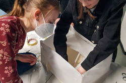 Two girls tinker with their house model