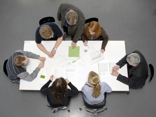 Bird's eye view: conference table with papers and people in consultation