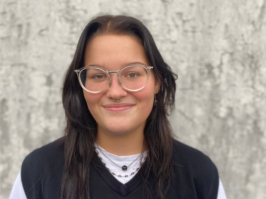 Ein Portrait einer jungen Frau mit dunklen Haaren und Brille