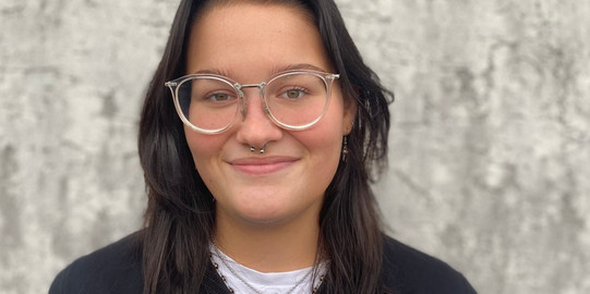 Ein Portrait einer jungen Frau mit dunklen Haaren und Brille