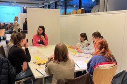 Eine MinTU Gruppe bestehend aus sechs Schülerinnen und einer Mentorin sitzen an einem Tisch.