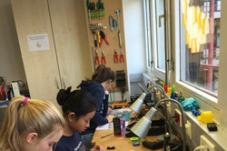 Mentees solder a carousel in a workshop