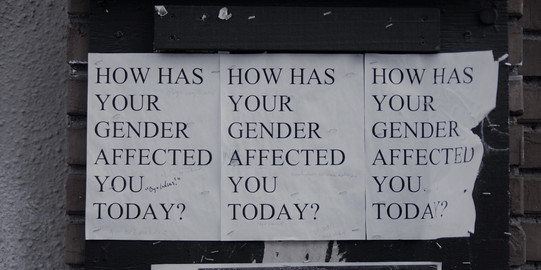 You can see three A4 sheets hanging next to each other with the slogan ‘How has your gender affected you today?’