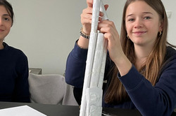 Ein Mädchen baut aus Papier Türme 