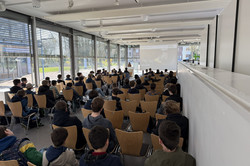 The Boys' Day participants sit in many rows of chairs. 