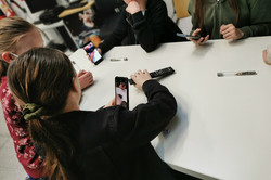 Girls work on a task with their smartphones
