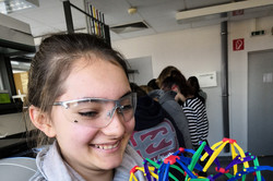 Ein Mädchen hält ein Modell eines Atoms in den Händen