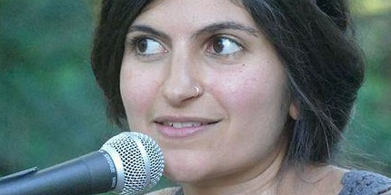 A young woman sits in front of a microphone