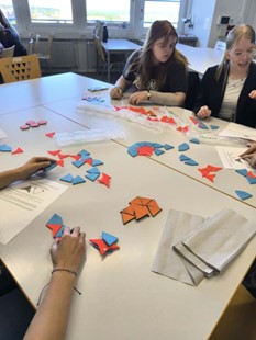 Eine Gruppe von MinTU-Teilnehmerinnen erforscht die "aperiodischen Parkettierung" anhand eines Modells.