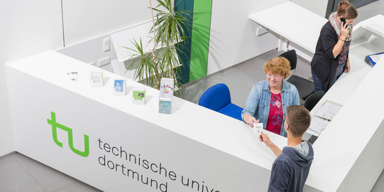 Ein Student gibt seine Wartenummer bei der Studienberatung ab.